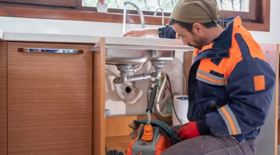 plumber cleaning a skin drain pipe