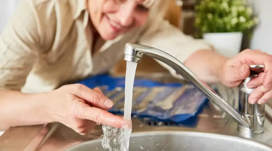 woman touching a water from a faucet